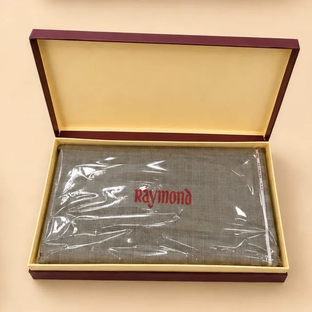The Mittal & Sons gift box open, with the chosen Raymond suit length folded inside